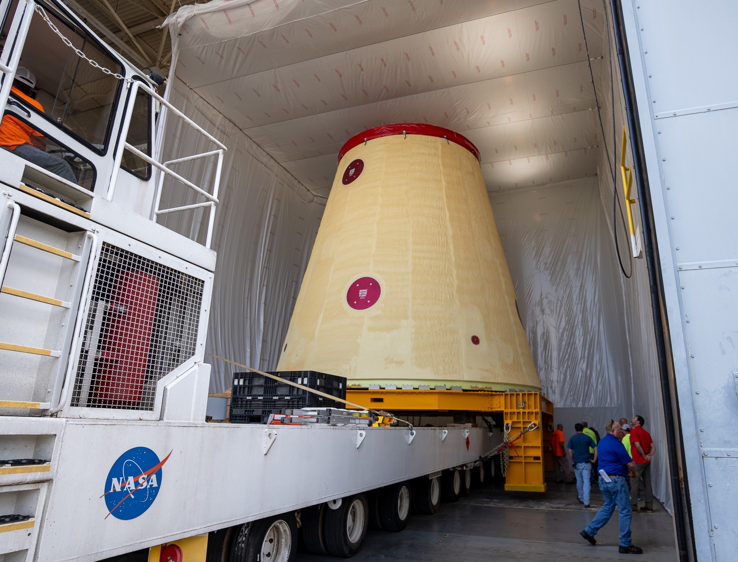 An image that shows crews preparing to move a key adapter for NASA’s Space Launch System rocket out of Marshall Space Flight Center’s Building 4708 to the agency’s Pegasus barge. The cone-shaped launch vehicle stage adapter connects the rocket’s core stage to the upper stage and helps protect the upper stage’s engine that will help propel the Artemis II mission around the Moon.