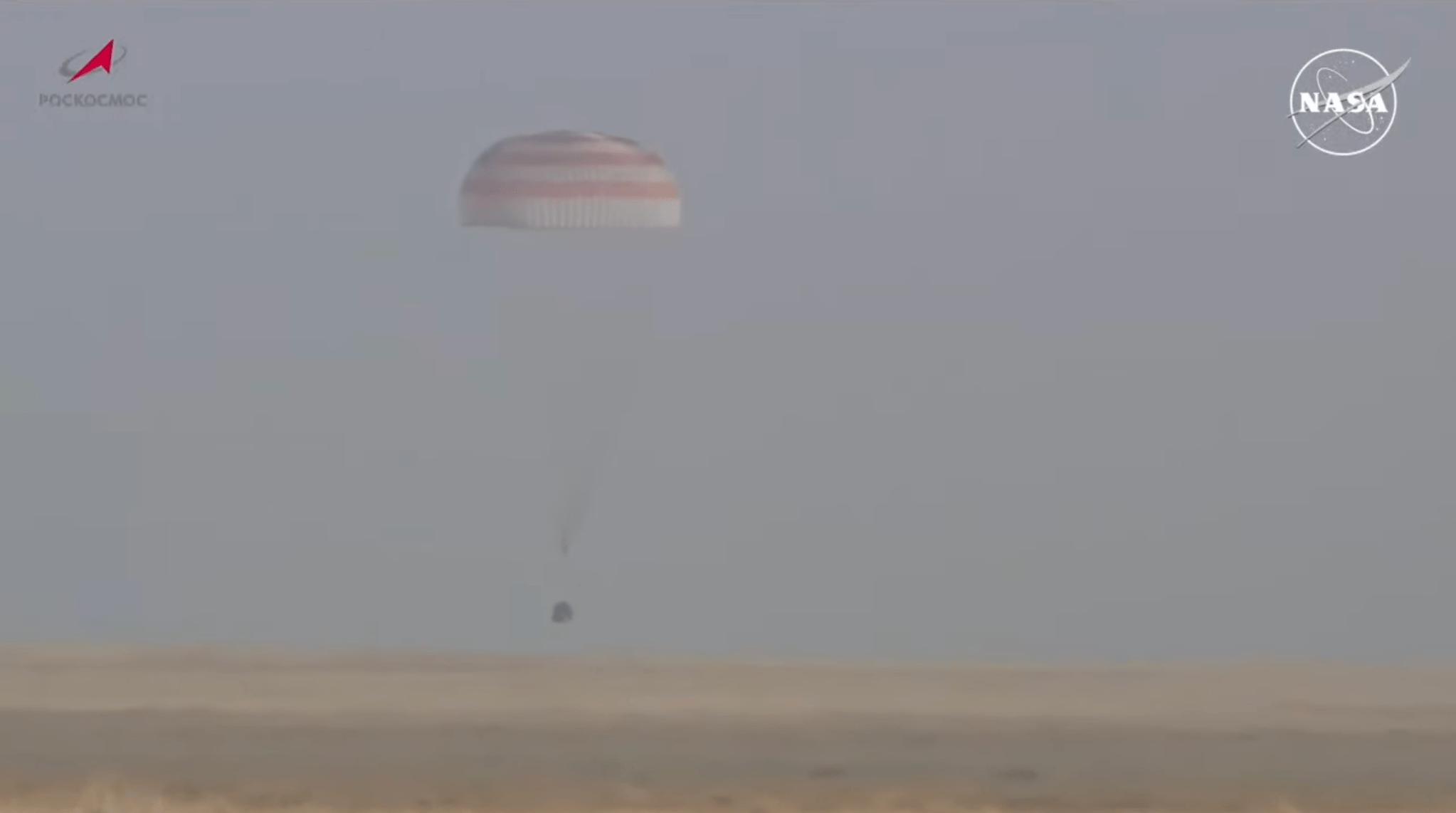 The crew capsule of the Soyuz MS-25 spacecraft parachutes toward the ground southeast of the remote town of Dzhezkazgan, Kazakhstan.