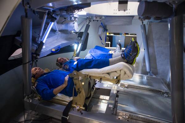 Astronauts Rick Linnehan and Mike Foreman try out a prototype display and control system inside an Orion spacecraft mockup at NASA’s Johnson Space Center in Houston during the first ascent and abort simulations for the program.
