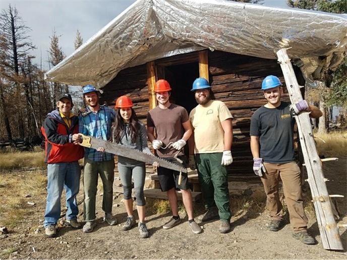 Title: Roof Work - Description: Students from Dr. Lee’s fall 2017 Wilderness Management class assisted Kaibab National Forest employees after a tree fell on the roof of Kendrick Mountain Cabin. Credit Kaibab National Forest.